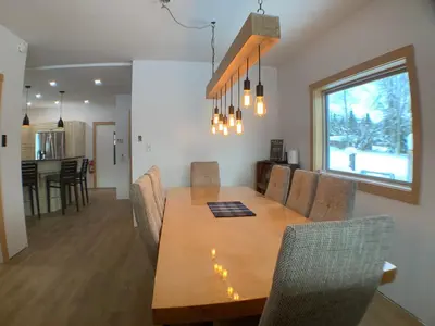 a dining room and kitchen with a wooden table and chairs at Eleanor Lodge - Entire House in Blue River in Blue River