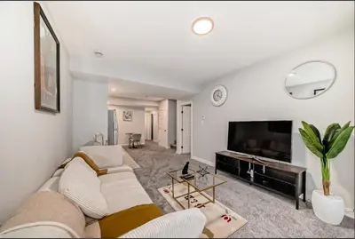 a living room with a couch and a tv at Cozy Basement Suite in Calgary