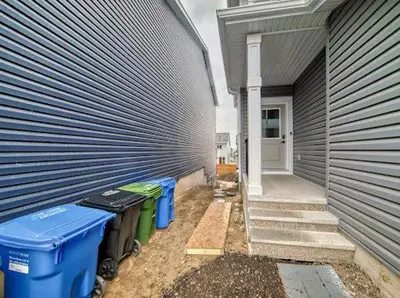 a large building with trash cans next to a house at Cozy Basement Suite in Calgary