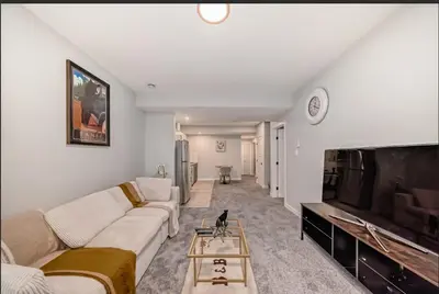 a living room with a couch and a flat screen tv at Cozy Basement Suite in Calgary