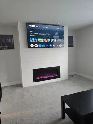 a living room with a fireplace with a tv on the wall at Private 1 bedroom in Brookswood in Langley