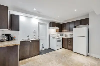 a kitchen with wooden cabinets and a white refrigerator at Private 1 bedroom in Brookswood in Langley
