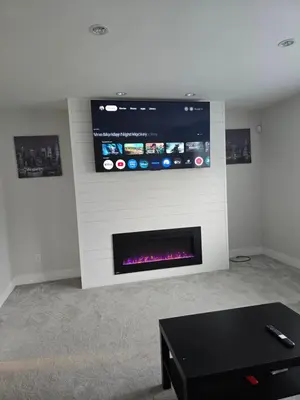 a living room with a fireplace with a tv on the wall at Private 1 bedroom in Brookswood in Langley
