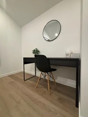 a black desk with a black chair and a mirror at cottage NOMAD in Ucluelet