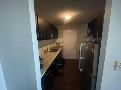 a kitchen with a sink and a refrigerator at florian Apartment in Calgary