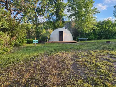 a tent in the middle of a grass field at D4 Badlands Bunker Dome- 1 Queen Pet Friendly in Drumheller