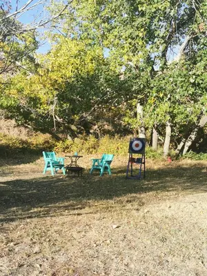 two blue chairs and a sign in a park at D4 Badlands Bunker Dome- 1 Queen Pet Friendly in Drumheller