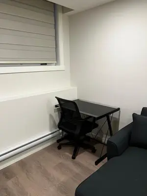 a office with a desk and a chair and a window at The Haven - cozy 1 bedroom suite in Seton SE Calgary in Calgary