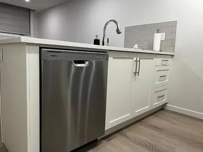 a kitchen with a sink and a dishwasher at The Haven - cozy 1 bedroom suite in Seton SE Calgary in Calgary