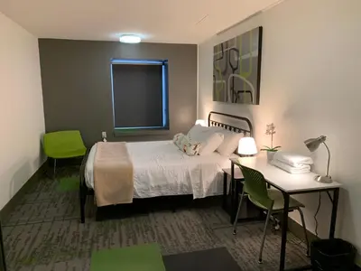 a bedroom with a bed and a table and chairs at HI Calgary City Centre - Hostel in Calgary
