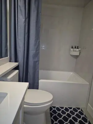a bathroom with a white toilet and a bath tub at Cozy Private Suite near YVR Airport in Vancouver