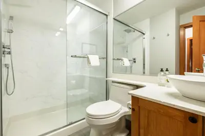 a bathroom with a shower and a toilet and a sink at Symphony by Outpost Whistler in Whistler