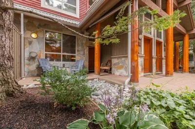 a front porch of a home with a stone fireplace at Symphony by Outpost Whistler in Whistler
