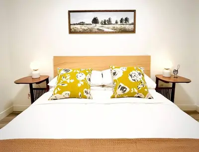 a bedroom with a bed with yellow and white pillows at T201 Brand NEW Downtown Canmore 3BD & 2BT, BBQ, Free Parking in Canmore
