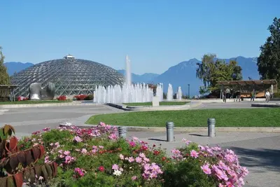 a fountain in a park with a building and flowers at Near Downtown YVR -2 Bedroom private suite in Vancouver