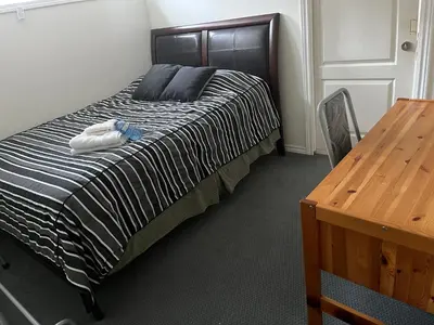 a bedroom with a bed and a wooden table at Near Downtown YVR -2 Bedroom private suite in Vancouver