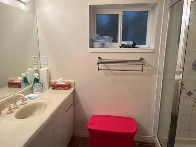 a bathroom with a sink and a red stool at Near Downtown YVR -2 Bedroom private suite in Vancouver