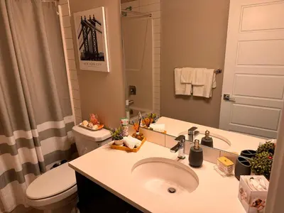 a bathroom with a sink and a toilet and a mirror at Z FamilyHome Suites & Apartments in Calgary