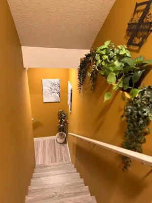 a hallway with stairs and plants on the wall at Z FamilyHome Suites & Apartments in Calgary