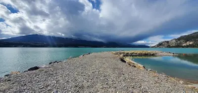 a large body of water with mountains in the background at Modern Condo Dream at Fairmont in Fairmont Hot Springs