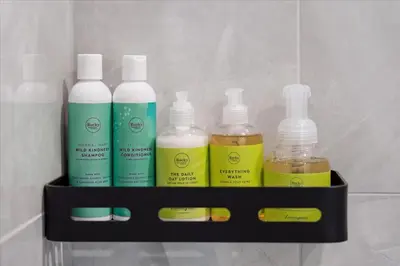 a shelf with four bottles of cleaning products on it at The Oak Hotel in Nelson