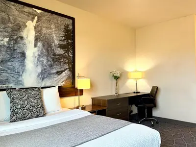 a hotel room with a bed and a desk at High Point Inn & Suites Peace River in Peace River
