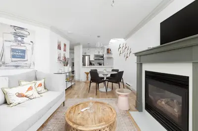 a living room with a white couch and a fireplace at Boutique Beach Apartment in Vancouver