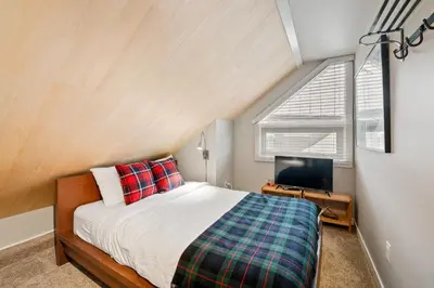 a bedroom with a bed and a tv and a window at The Crest, Spacious, Central Condo, Free Parking in Whistler