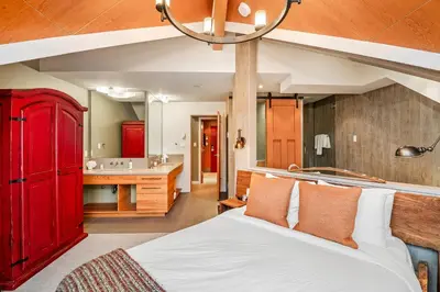 a bedroom with a red bed and a bathroom at The Nest, Central, Luxury Unit, Free Parking in Whistler