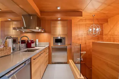 a kitchen with stainless steel appliances and wooden walls at The Den, Heart of Village, Free Parking in Whistler