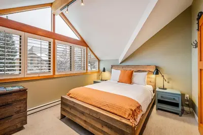 a bedroom with a large bed and windows at The Den, Heart of Village, Free Parking in Whistler