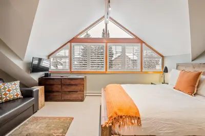 a bedroom with a large bed and a couch at The Den, Heart of Village, Free Parking in Whistler