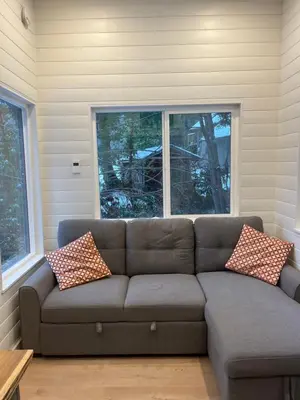 a living room with a couch in front of a window at Malaspina Strait Tiny Home in Powell River
