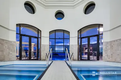 an indoor swimming pool with windows and a swimming poolvisorvisor at The Royal Kelowna - Bellstar Hotels & Resorts in Kelowna