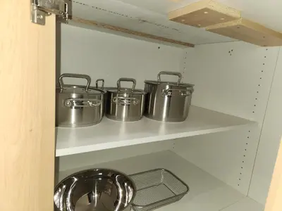 four pots and pans on a shelf in a kitchen at Brand New Deluxe 2 Bedroom Suite with AC & Den in Calgary