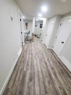 a hallway of an empty room with wood floors at Charming 2-Bedroom Basement Oasis Sleeps 5,Size-150sqm, Netflix, family friendly in Edmonton