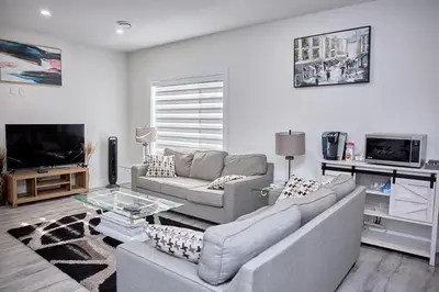 a living room with a couch and a tv at Brand-new three bedroom guest suite in the desirable neighbourhood in Prince George
