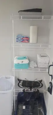 a closet with towels and other items on shelves at A Cozy home away from home at South East Calgary in Calgary
