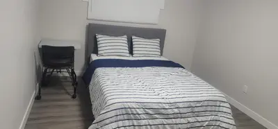 a bedroom with a bed with a black and white comforter at A Cozy home away from home at South East Calgary in Calgary