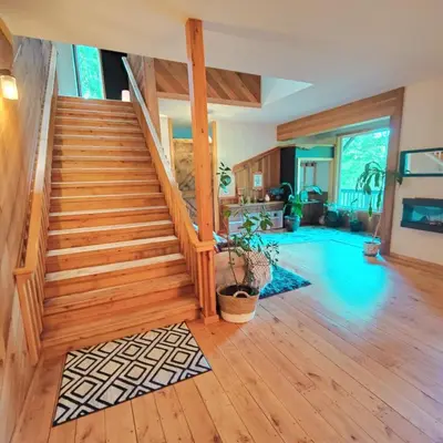 a living room with a staircase and a swimming pool at Hummingbird B&B in Gabriola