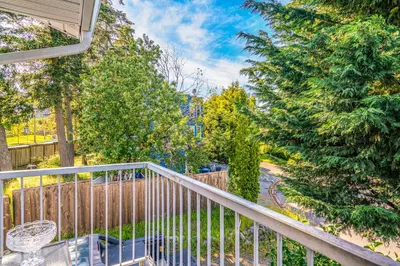 a balcony with a table and chairs and trees at Entire home minutes from 3 lakes and a river! in Nanaimo