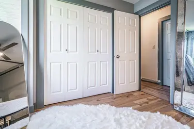 a bedroom with a mirror and a white door at Entire home minutes from 3 lakes and a river! in Nanaimo