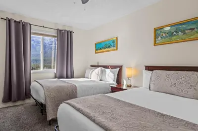 a hotel room with two beds and a window at B212 Hot Tub, AC x3, parking, 2 min to Banff Gate in Canmore