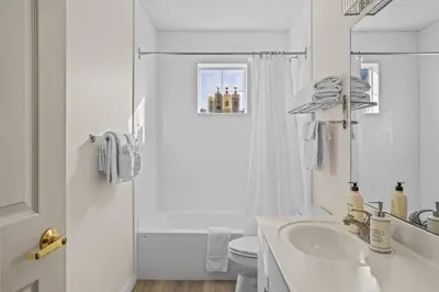 a white bathroom with a sink and a toilet at B212 Hot Tub, AC x3, parking, 2 min to Banff Gate in Canmore