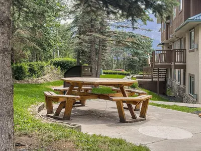 a picnic table with two benches in a park at B212 Hot Tub, AC x3, parking, 2 min to Banff Gate in Canmore