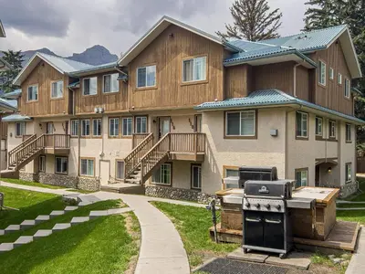 a large house with a grill in front of it at B212 Hot Tub, AC x3, parking, 2 min to Banff Gate in Canmore