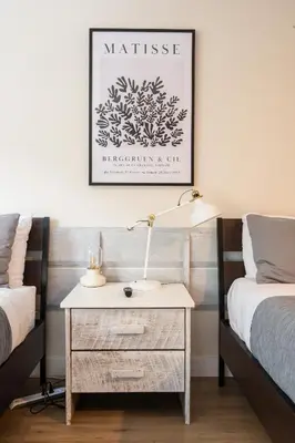 a bedroom with two beds and a nightstand with a lamp at Creekside Oasis 4 Beds Pool and Hot Tub in Whistler