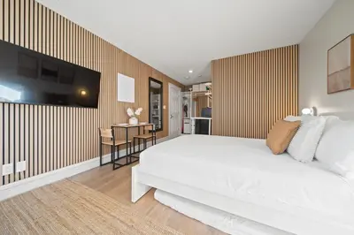 a bedroom with a large white bed and a desk at Cozy Creek Den - Updated Nov 2025 in Whistler