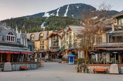 a street in a town with buildings and a mountain at Cozy Creek Den - Updated Nov 2025 in Whistler