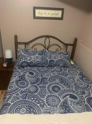 a bed with a blue and white blanket and pillows at Cozy Lodge Suite in Sylvan Lake